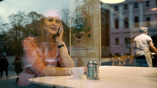 妇女在咖啡馆用手机聊天视频