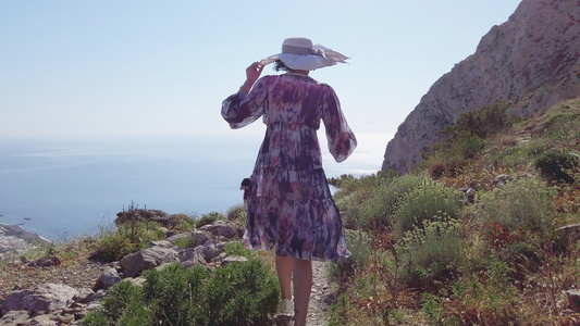 女人走在圣坦托里尼的路上在古代神话中的海边漫步视频