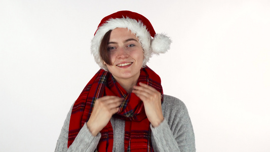 穿着圣诞帽子和冬围巾的快乐妇女向相机微笑视频
