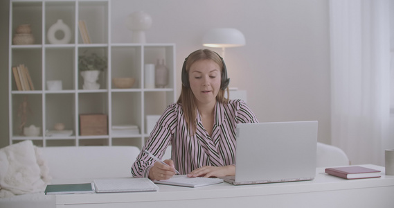 年轻妇女离家工作很远通过笔记本电脑视频聊天进行在线视频