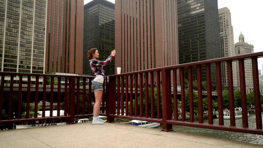 年轻美女拍现代城市摩天大楼的移动照片视频