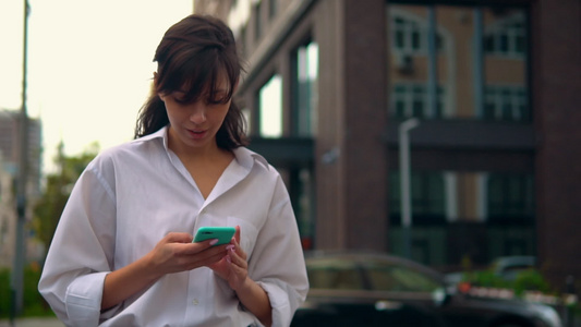 城里使用智能手机散步的caucasians女人视频