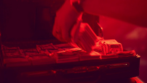 男人用手从红色背光的箱子里拿钱装满了钱6秒视频