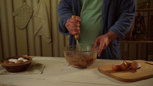 男人在厨房的玻璃碗里将烘烤成的料自己做蛋糕视频