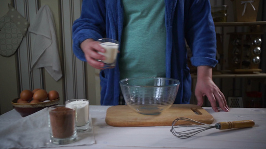 做厨师男人把巧克力蛋糕的配料加到玻璃碗里[厨工]视频
