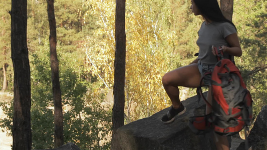 女性远足者坐在岩石上视频