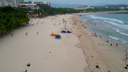 海南省三亚市三亚湾大东海旅游区沙滩上的旅游游客视频