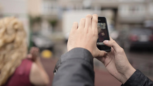 年轻男子在手机上拍摄女友在街上玩得开心的手机照片10秒视频