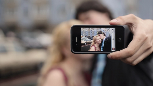 年轻夫妇在手机上自拍玩乐的街头小情侣视频