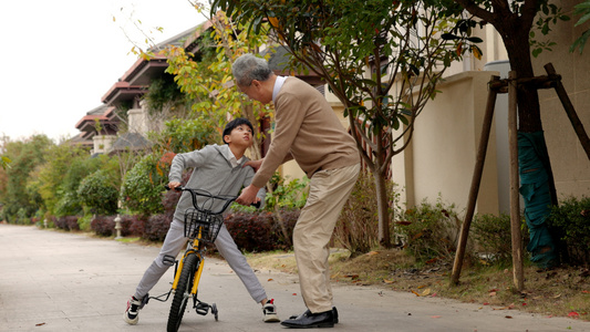 爷爷保护骑自行车的孙子视频