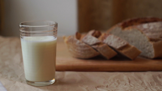 厨房餐桌上的牛奶和切片面包杯早餐时的奶制品视频