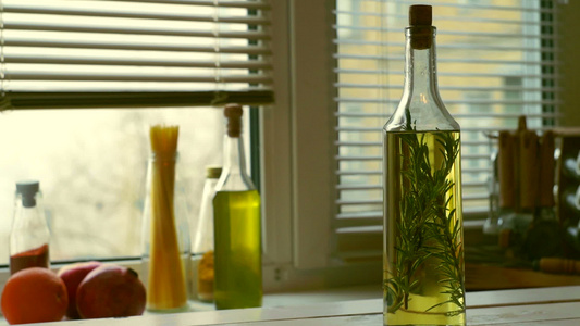 厨房背景的烹饪油瓶橄榄加迷迭香视频
