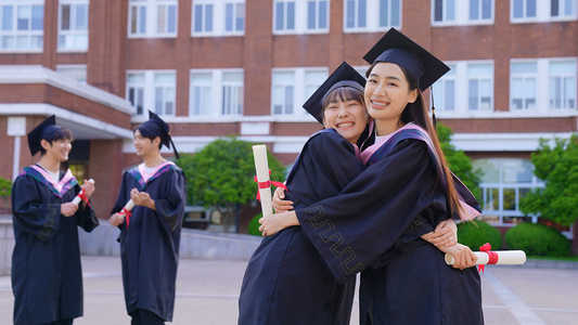 穿学士服的学生毕业拥抱视频