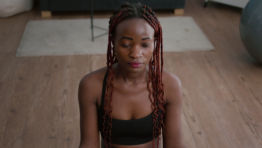 坐在莲花姿势下伸展身体肌肉的黑人女子肖像视频
