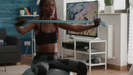在健身球上用瑜伽乐队做瑜伽锻炼的黑人女性视频