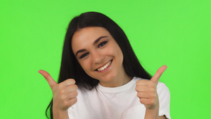 一个快乐的女孩竖起拇指在绿色背景上7秒视频