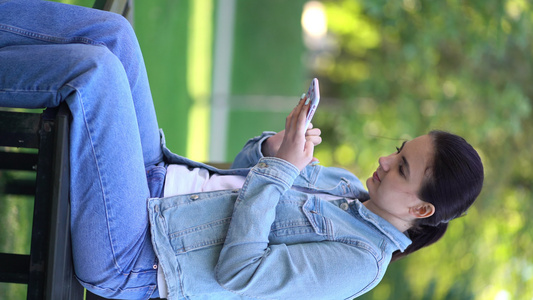 女性在公园里用智能手机聊天在公园里视频
