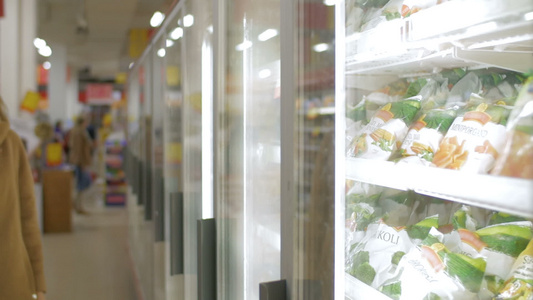 妇女在商店冰箱中服用冷冻产品视频