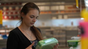 妇女在一家商店购买一个食品塑料集装箱的商店中14秒视频