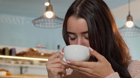 低角度拍摄一个美丽的女人微笑在镜头前拿着一杯咖啡的视频