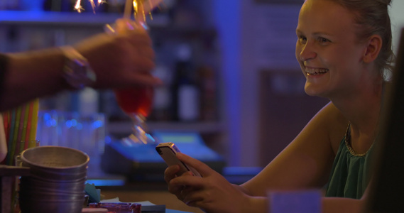 妇女用智能手机订购鸡尾酒和火花视频