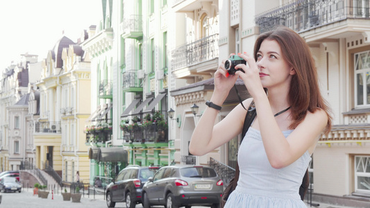 美貌美丽的女人在她反光照相机上拍摄城市照片视频