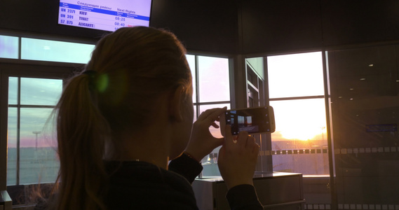 妇女用牢房拍摄日落照片视频