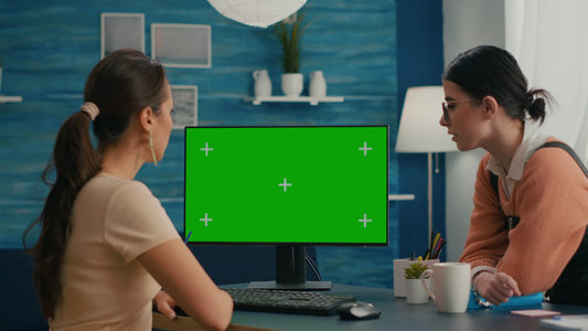 坐在电脑绿色屏幕前的两位朋友在模拟计算机绿色屏幕上视频