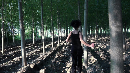 追逐一个害怕的女人在树林间的森林里奔跑女孩试图逃离视频