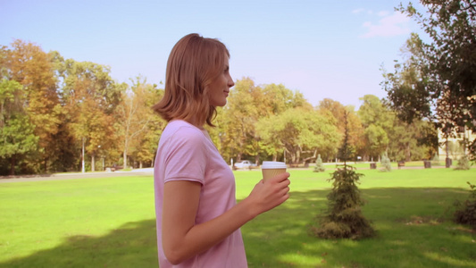 金发女人在公园喝咖啡视频