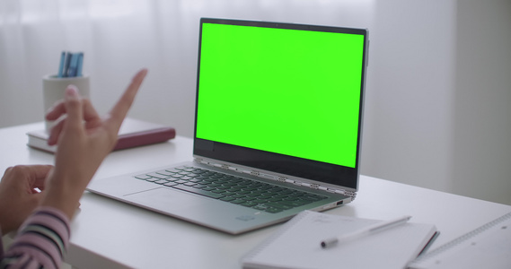 妇女通过笔记本电脑视频聊天与染色体关键技术绿屏进行视频