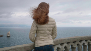 年轻苗条的女人长着棕色的长发站在阳台19秒视频