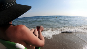 坐在海边沙椅上享受风景的女用草帽和女用草帽20秒视频
