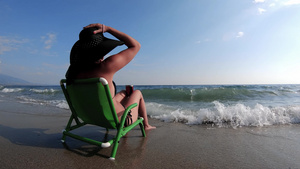 坐在海边喝着咖啡的泳衣上慢动作的年轻美女们看背影23秒视频