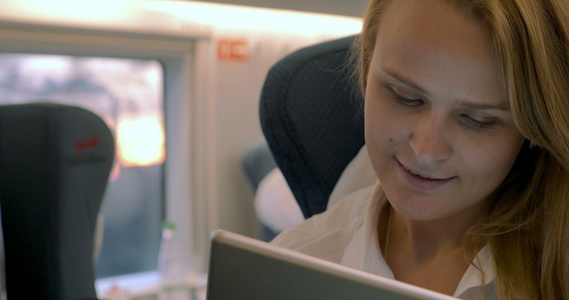女商人在火车上使用电子平板电脑视频