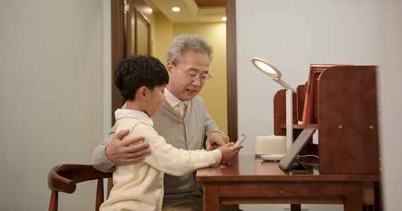 孙子在书房教爷爷使用手机视频