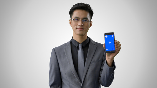4k灰底抠像商务男性展示蓝幕手机视频