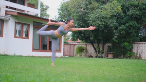 女舞者用瑜伽姿势在她家的花园里摆姿势20秒视频