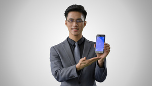 4k灰底蓝幕合成戴眼镜的商务男性展示手机动作9秒视频
