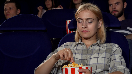 电影首映时吃爆米花的有吸引力的女性视频