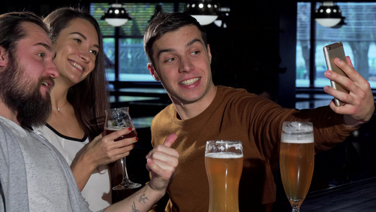 一群朋友用智能手机拍自拍同时一起喝酒喝啤酒视频
