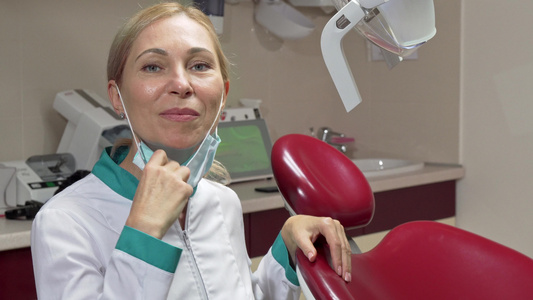 成熟成熟的女牙医脱下医疗面具微笑着笑容视频