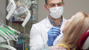 戴医疗面具检查女性病人牙齿的男男性牙科牙医12秒视频