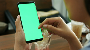 女人在咖啡店使用带有绿屏模型的移动智能手机11秒视频