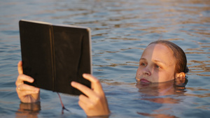 妇女漂浮在海中时正在读书16秒视频