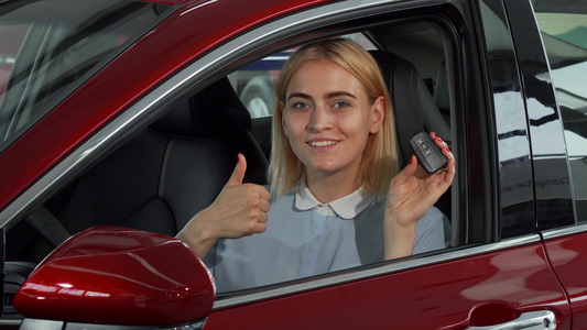快乐的女司机展示她的车钥匙和拇指视频
