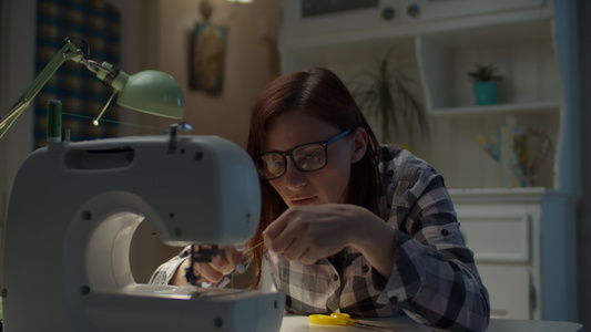 30多岁的年轻女人正在调整在家工作的缝纫机戴眼镜的视频
