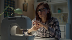 30多岁的年轻女人正在调整在家工作的缝纫机戴眼镜的42秒视频