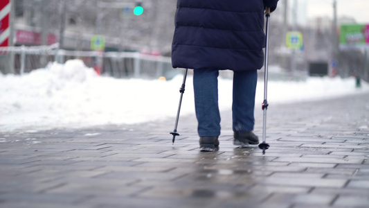 活跃的老年妇女用登山杖训练北欧式行走冬天在户外练习视频