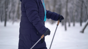 活跃的老年妇女用登山杖训练北欧式行走冬天在户外练习11秒视频